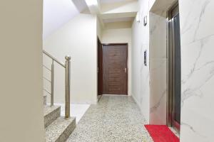 a hallway with a wooden door and a red rug at FabHotel Bungalow 14 - Collectrate in Jaipur +31 photos