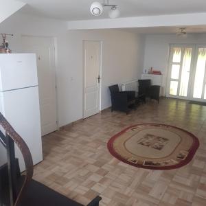a living room with a white refrigerator and a table at Pensiunea Ovidiu in Beclean