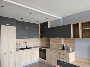 ヴァルナ・シティにあるEuroproperties SkyLine Apartmentsの木製のキャビネットとシンクを備えたキッチン