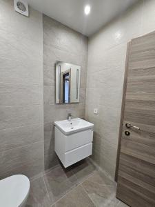 ヴァルナ・シティにあるEuroproperties SkyLine Apartmentsの洗面台、トイレ、鏡のあるバスルーム