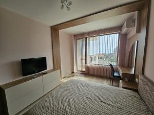 ヴァルナ・シティにあるEuroproperties SkyLine Apartmentsのリビングルーム(テレビ、大きな窓付)