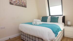 a bedroom with a bed with towels on it at StayZo Premiere Serviced Accommodation-17 in Southampton +6 photos