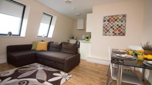 a living room with a couch and a table at StayZo Serviced Accommodation 16 Premier Lodge in Southampton +17 photos