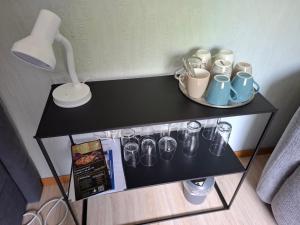 a black table with glasses on it with a lamp at Hochwald EnSuite in Bad Sachsa