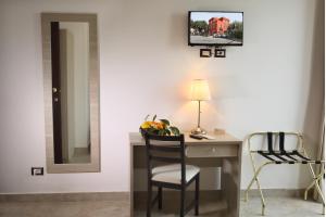 a room with a desk with a chair and a mirror at Villa Astoria in Taormina