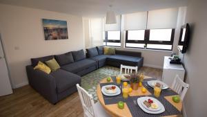 a living room with a couch and a table with food on it at StayZo Castle Point 6 Apartment - Premier Lodge in Southampton +10 photos