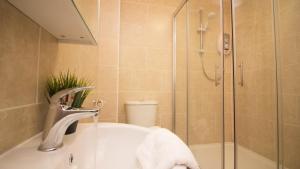 a bathroom with a shower and a sink and a tub at StayZo Castle Point 6 Apartment - Premier Lodge in Southampton