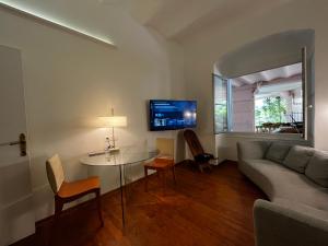 ein Wohnzimmer mit Tisch und Couch in der Unterkunft Appartement Ombragé 44m2 Riviera Palace Belle-Epoque, Restomod et Literie Prestige in Menton