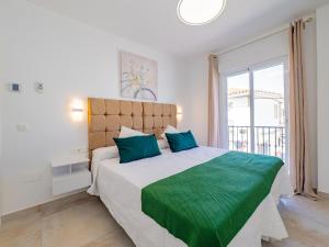 ein Schlafzimmer mit einem großen Bett mit grüner Bettwäsche und einem Fenster in der Unterkunft Cubo's La Perla Town Center House in Alhaurín el Grande