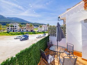 einen Balkon mit einem Tisch und Stühlen sowie einen Parkplatz in der Unterkunft Cubo's La Perla Town Center House in Alhaurín el Grande
