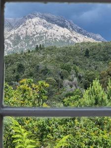 a view of a mountain from a window at Owen Cottage Queenstown Genuine Comfort and Views in Queenstown