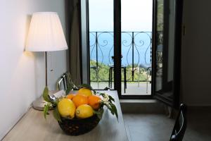 a bowl of fruit on a table with a lamp at Villa Astoria in Taormina