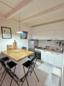 a kitchen with white cabinets and a wooden table and chairs at Mrežnica - Zelena oaza I in Generalski Stol
