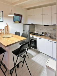a kitchen with white cabinets and a table and chairs at Mrežnica - Zelena oaza I in Generalski Stol +29 photos