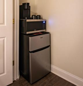 a microwave sitting on top of a refrigerator at 2bd-2ba Adorable Home w Yard in Gentilly in New Orleans