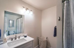 a bathroom with a sink and a mirror at 2bd-2ba Adorable Home w Yard in Gentilly in New Orleans +8 photos