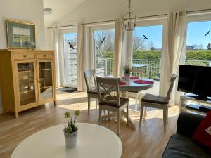 a living room with a table and chairs and a television at Boardinghouse in Büsum