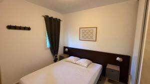 a bedroom with a bed with white sheets and a window at Appartement 2 pièces bord de mer in Linguizzetta +37 photos