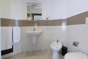 a bathroom with a sink and a toilet and a mirror at Villa Astoria in Taormina