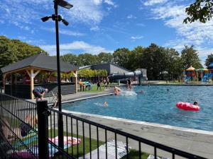 a pool with people in the water at a park at Milos Ferienhaus mit Flussblick in Lathum