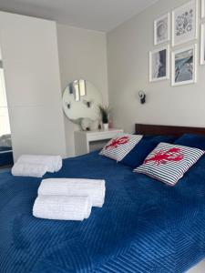 ein blaues Bett mit Handtüchern darüber in der Unterkunft Natura Resort Rozewska in Jastrzębia Góra