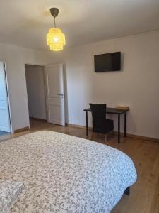 a room with a bed and a table and a television at la taverne forezienne in Saint-Sixte