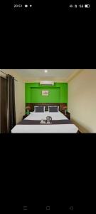 a green bedroom with a bed and a sink at Hotel Elite Stay in Gurgaon +6 photos