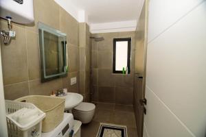 a small bathroom with a sink and a toilet at Seaside Serenity Apartments - Tirana Resort Radhime in Vlorë +53 photos