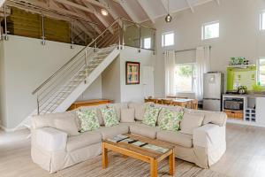 a living room with a couch and a staircase at The Suites at Waterryk Eco Guest Farm in Stilbaai
