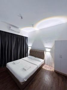 a bedroom with a large bed with white sheets at Doyar's Home Stay "Palm Garden -Ground Floor" in Lahad Datu