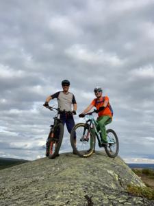 two men standing on top of a rock with their bikes at Charming Cabin with Old Timber, Fireplace & Views in Beitostøl