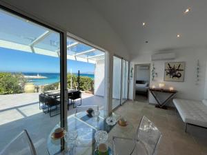 a living room with a glass table and a view of the ocean at PIEDS DANS l EAU A SANT AMBROGGIO in Lumio