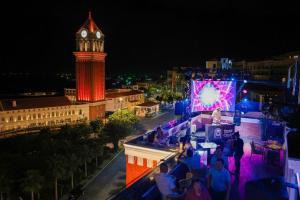a view of a city at night with a clock tower at Times Corner Amalfi Hotel in Phú Quốc