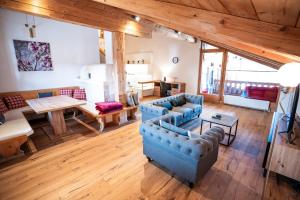 uma grande sala de estar com sofás azuis e uma mesa em Apartment Kracherlemoos em Seefeld in Tirol