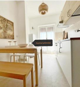 a kitchen with a table with a sign that reads optimal loneliness at Vacanze romane in Rome +14 photos