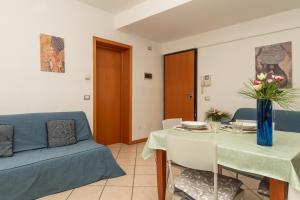 a living room with a table and a blue couch at Ca di Mar 4 in Caorle