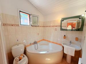 ein Badezimmer mit Badewanne, Toilette und Waschbecken in der Unterkunft Myrtos Hotel in Divarata