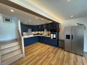 a kitchen with blue cabinets and a stainless steel refrigerator at The Old Workshop in Portree