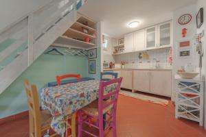 a kitchen with a table and chairs and a staircase at Casa Celeste - Goelba in Pomonte