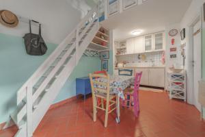a kitchen with a table and chairs and a staircase at Casa Celeste - Goelba in Pomonte +6 photos