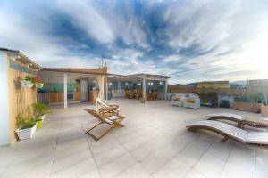 a patio with chairs and tables on a building at Rooms and Rooftop Terrace Olbia Center in Olbia