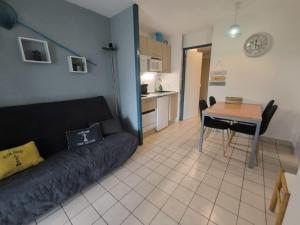 a living room with a couch and a table at Studio 4 pers / terrasse / espace aquatique in Talmont