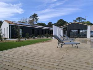 a group of benches on a patio in front of a building at Le Logis de Raphabel in Saint-Palais-sur-Mer
