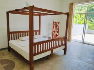 a bedroom with a wooden canopy bed with white sheets at Villa Idda in Padukka +38 photos