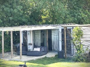 a pergola with a couch sitting on a deck at Le Mazet Chambre d'Hôtes in Mauguio