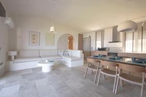 un salon avec un canapé, une table et des chaises dans l'établissement Thani Beach House, Elani by Halkidiki Villas, à Elani