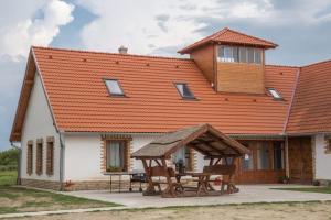 a house with an orange roof with a picnic table at István lovas tanya in Kiskőrös