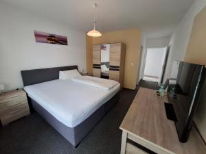 a bedroom with a large bed and a table at Landhotel Solmser Hof in Echzell