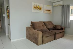 a brown couch sitting in a living room at 500m PRAIA de Taperapuan; 2 quartos; WiFi 300mbs; 2 pavimento; Churrasqueira; Chuveirão; Estacionamento Gratuito 1 carro in Porto Seguro