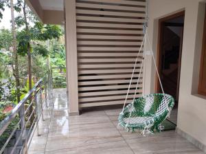 a swing on the porch of a house at VILLA VISTA Apt RENTAL in Alleppey